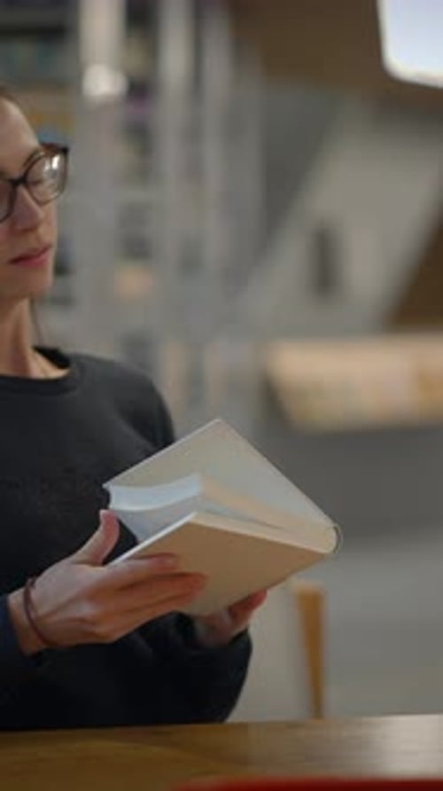 An Individual in the Library is Engaging Deeply with Books and Resources for Learning