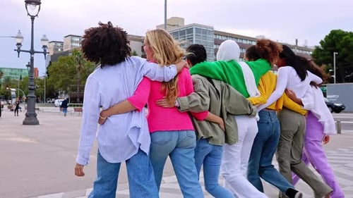 Vista traseira de um grupo jovem de mulheres diversas caminhando juntas e abraçando o ar livre