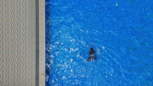 Schwimmer gleitet im modernen Außenpool durch türkisfarbenes Wasser