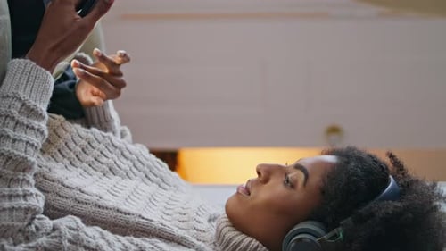 Woman Lounging with Smartphone and Headphones