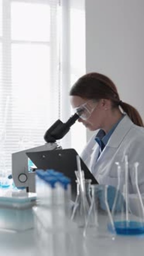 Scientist Using Microscope in Brightly Lit Laboratory
