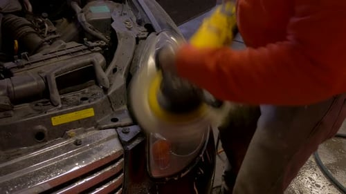 Polishing Car Headlight in Auto Repair Shop