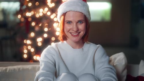 Smiling Woman with Santa Hat by Christmas Tree