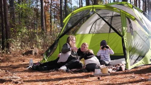 A Cozy Tent in the Forest is a Place for Warm Family Conversations The Family Relaxes with Laughter
