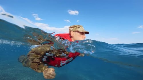 Man Swims with Life Vest in Ocean Water