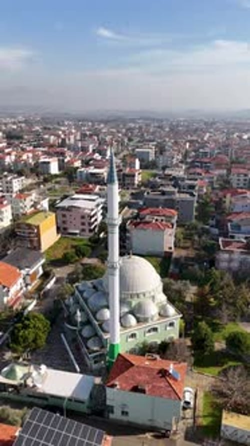 Vue aérienne verticale de la mosquée et des champs agricoles avec la ville en arrière-plan