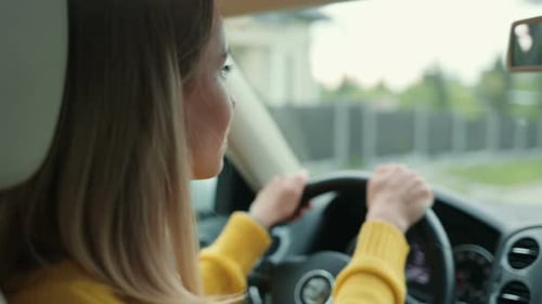 Jovem mulher caucasiana séria está dirigindo um carro em uma estrada olhando para a tela do carro, sentindo-se concentrada