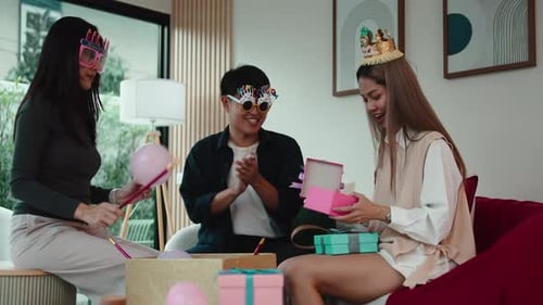 Friends Celebrate Birthday with Gifts and Balloons Indoors