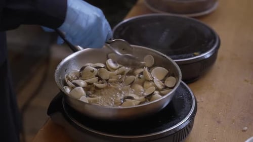 palourdes sautées dans une poêle sur une cuisinière électrique pendant la préparation des fruits de mer