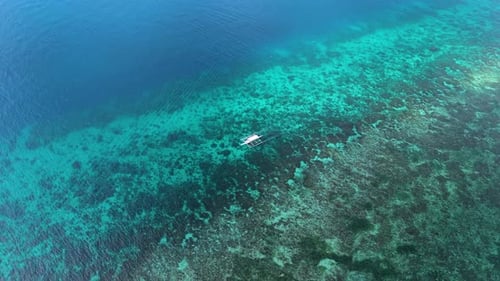 Vue aérienne par drone d'un bateau de pêche dans les eaux vives de l'océan sur l'île de Bohol, Philippines