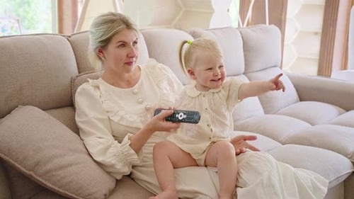 Mother and Toddler Daughter Relaxing on Sofa