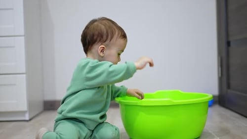 Cute Infant Crawling out of Green Basin Indoors