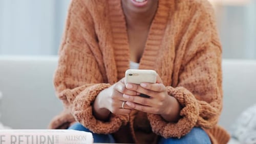 Woman Using Smartphone While Relaxing on Sofa