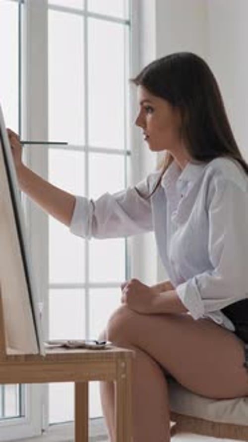 Young Woman Painting in Bright Room Studio