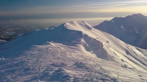 Sunset Aerial View of Frozen Alpine Ridge in Winter Mountains