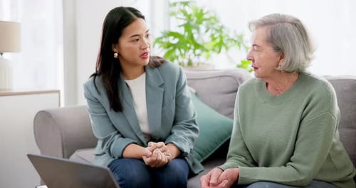 Two Women Talking on a Couch at Home