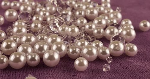 White pearls, clear jewelry crystals and rock crystal on pink velvet.