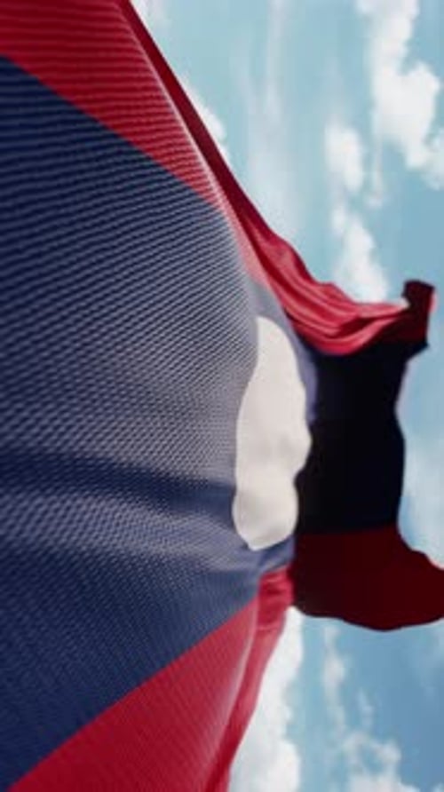 Die wellenförmige Flagge von Laos weht in Zeitlupe im Wind und schwenkt das farbenfrohe Teamsymbol der laotischen Flagge