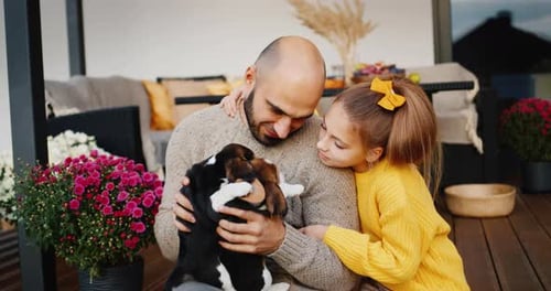 Man and Girl Cuddle Adorable Beagle Puppies
