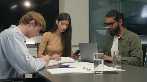 Team Collaborating on Laptop in Modern Office Setting