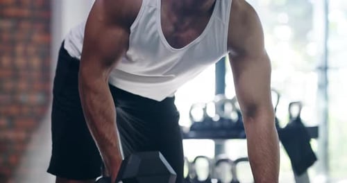 4k video footage of a handsome young man lifting weights in the gym