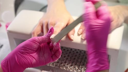 Woman Filing Nails in Manicure Beauty Salon
