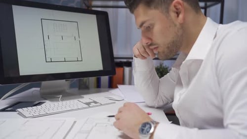 Male architect designing rooms of a new house in architecture office.