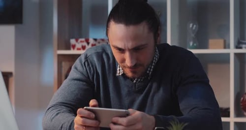 A Focused Man Engaged in Using a Tablet in a Contemporary Modern Workspace Environment