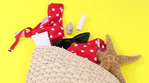 Tasche mit Strandaccessoires auf gelbem Hintergrund, Nahaufnahme