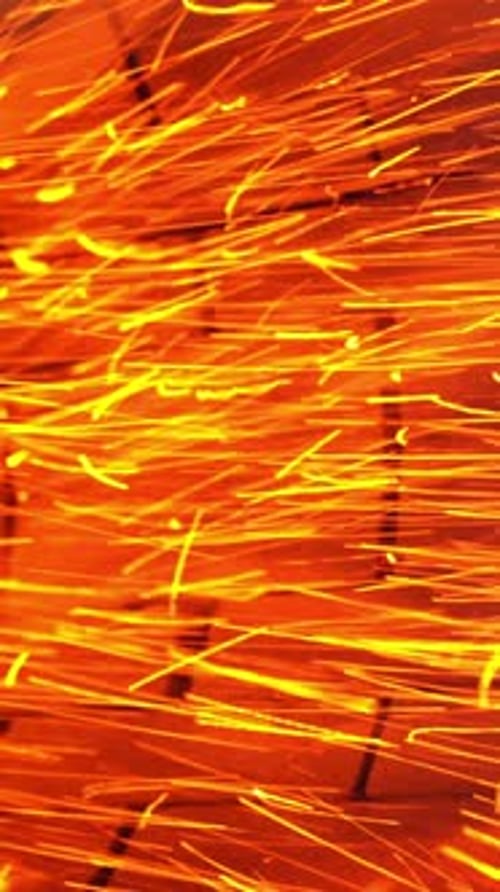 Kleine orangefarbene Funkeln fliegen schnell aus einem Ofenrohr.
