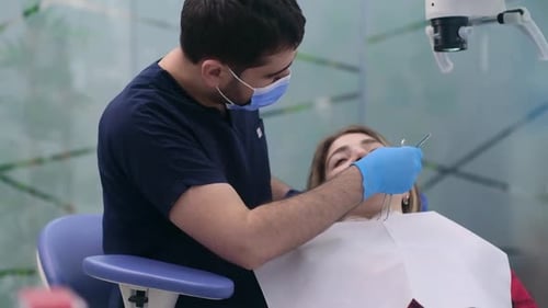 Dentistry Clinic Focused Dentist in Protective Mask Checking Teeth of Young Patient