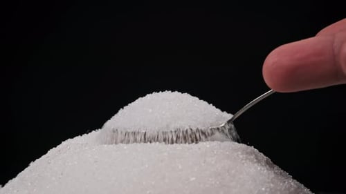 Getting Spoon Full of Sugar From Heap of Sugar on Black Background Slow Motion