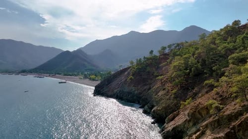 Sunlight Reflects on the Turquoise Water of the Mediterranean Sea A Rocky Coastline with Lush Green