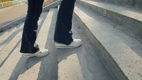 Young Woman Wearing Blue Jeans and White Sneakers Up the Stairs Closeup Female Walking in the City