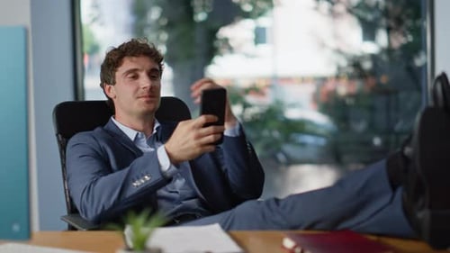 Young Man Relaxing with Mobile Phone at Work
