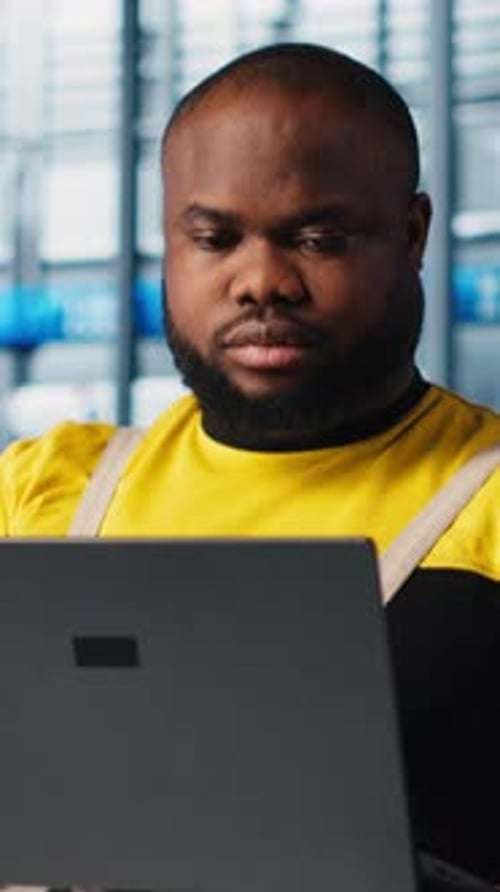 Vertical Video Happy Engineer Uses Laptop in Industry 40 Industrial Plant to Install Machinery