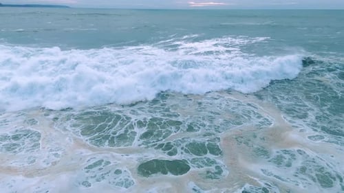 Ocean Waves Crashing in Foamy Patterns at Sunset
