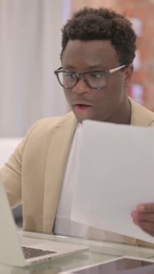 Young Adult Man Working With Laptop and Documents