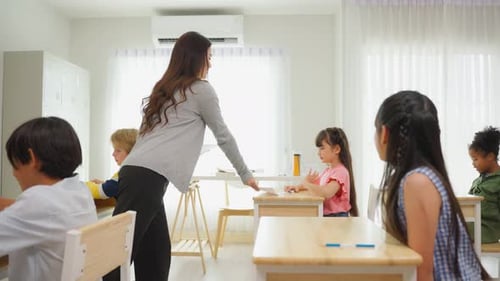 Group of student learn with teacher in classroom at elementary school.