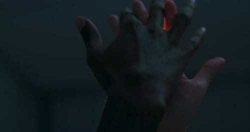 Intimate Hands Caress in a Dark Setting