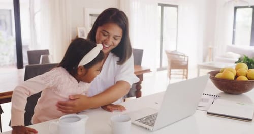 Daughter and working mother, single parent or small business entrepreneur typing on a laptop