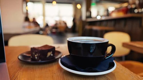 Enjoying a Delightful Cup of Coffee and a Delicious Dessert in a Cozy Cafe Environment is Truly