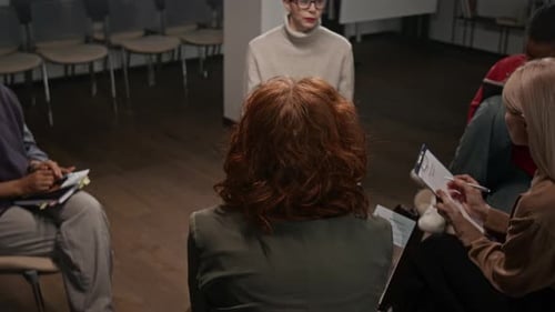 Jeune femme aux cheveux roux participant à un groupe de soutien