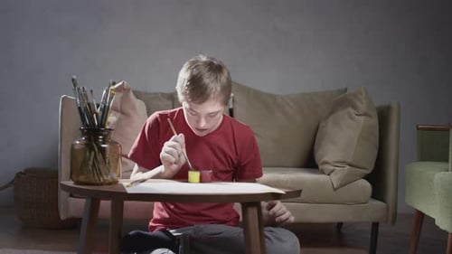 Boy Painting on the Floor in a Home Interior