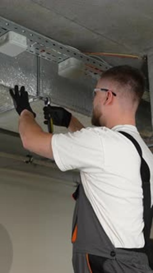 Electrician Working on Wires in a Building