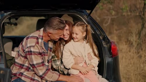 Happy Family Smiling Together in Car Trunk