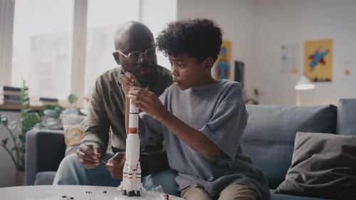 Little Kid Building Rocket Model with Father at Home