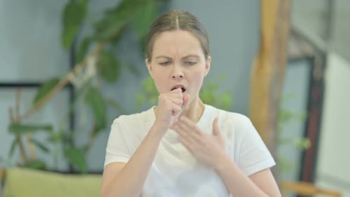 Woman Coughing Indoors, Demonstrating Illness Symptoms