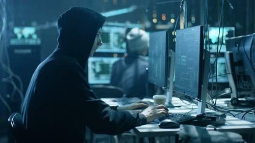 Un hacker cagoulé s'introduit dans les serveurs de données de l'Entreprise depuis sa cachette souterraine. L'endroit a une atmosphère sombre