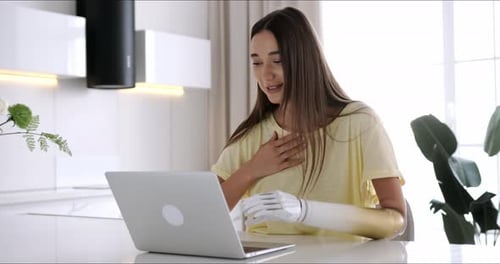Woman with Prosthetic Arm Using Laptop
